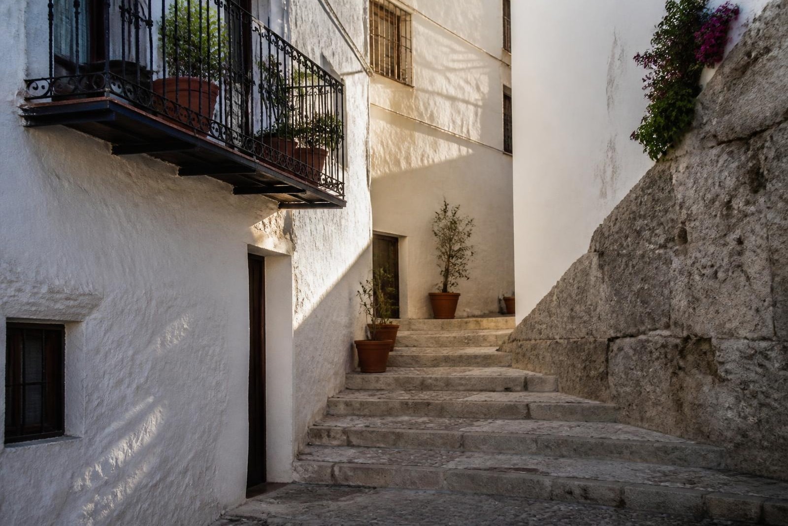 Sunlit whitewashed alley and worn stone steps in an Andalusian old town